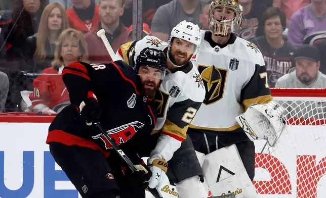 Carolina Hurricanes' Jordan Martinook (48) battles for position with Vegas Golden Knights' Shea Theodore (27) in front of goaltender Carter Hart (79) during the first period in Game 2 of the NHL hockey Stanley Cup Final series in Raleigh, N.C., Thursday, June 4, 2026. (AP Photo/Karl DeBlaker)