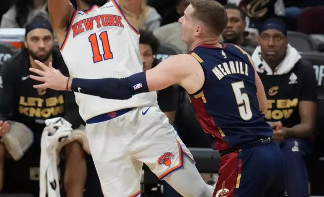 New York Knicks guard Jalen Brunson (11) shoots against Cleveland Cavaliers guard Sam Merrill (5) during the second half of Game 4 in the Eastern Conference finals NBA basketball playoffs series in Cleveland, Monday, May 25, 2026. (AP Photo/Sue Ogrocki)