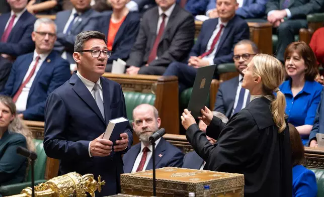 Andy Burnham, front left, is sworn-in as an MP in the House of Common in London, England, Monday, June 22, 2026. (House of Commons via AP)