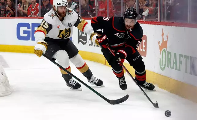Carolina Hurricanes' Sebastian Aho (20) moves the puck in front of Vegas Golden Knights' Noah Hanifin (15) during the second period in Game 5 of the NHL hockey Stanley Cup Final series in Raleigh, N.C., Thursday, June 11, 2026. (AP Photo/Karl DeBlaker)