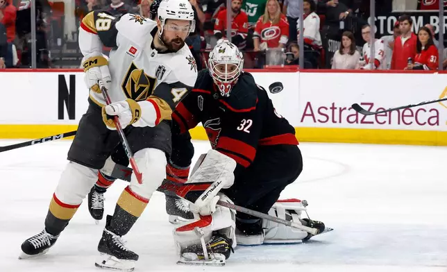 Carolina Hurricanes goaltender Brandon Bussi (32) watches the puck with Vegas Golden Knights' Tomas Hertl (48) during the third period in Game 5 of the NHL hockey Stanley Cup Final series in Raleigh, N.C., Thursday, June 11, 2026. (AP Photo/Karl DeBlaker)