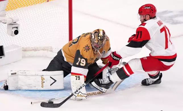 Vegas Golden Knights goaltender Carter Hart, left, stops a shot by Carolina Hurricanes left wing Taylor Hall during the first period in Game 4 of the NHL hockey Stanley Cup Final series Tuesday, June 9, 2026, in Las Vegas. (AP Photo/Candice Ward)