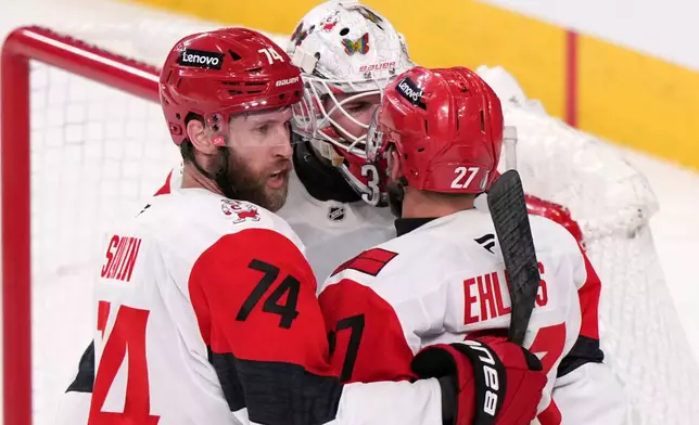 Carolina Hurricanes left wing Nikolaj Ehlers, right, celebrates his empty net goal with defenseman Jaccob Slavin, left, and goaltender Brandon Bussi during the third period in Game 4 of the NHL hockey Stanley Cup Final series against the Vegas Golden Knights, Tuesday, June 9, 2026, in Las Vegas. (AP Photo/Candice Ward)