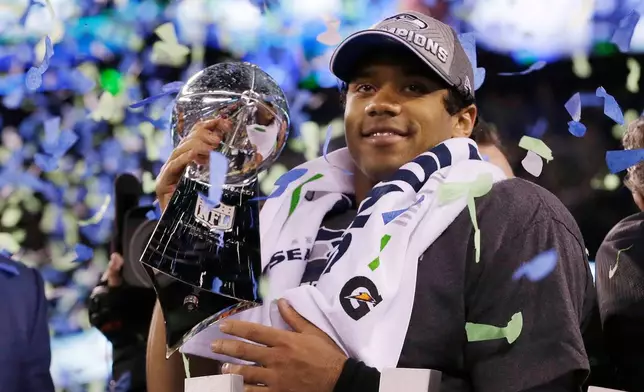 FILE - Seattle Seahawks' quarterback Russell Wilson holds the Lombardi Trophy after the NFL Super Bowl XLVIII football game, Feb. 2, 2014, in East Rutherford, N.J. (AP Photo/Julio Cortez, File)