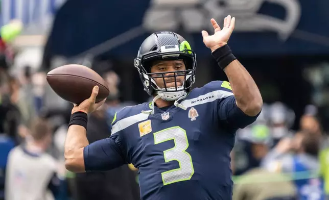 FILE - Seattle Seahawks quarterback Russell Wilson passes the ball during warmups before an NFL football game against the Arizona Cardinals, Nov. 21, 2021, in Seattle. (AP Photo/Stephen Brashear, File)