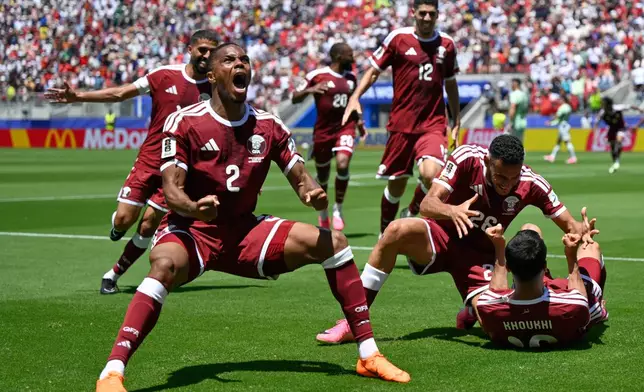 Qatar's Pedro Miguel, yells as he celebrates after teammate Qatar's Boualem Khoukhi, right scored his sides first goal during the World Cup Group B soccer match between Qatar and Switzerland in Santa Clara, Calif., near San Francisco, Saturday, June 13, 2026. (AP Photo/Eakin Howard)
