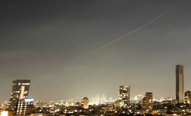 A projectile streaks through the sky over central Israel during an Iranian missile attack, Sunday, June 7, 2026. (AP Photo/Ohad Zwigenberg)