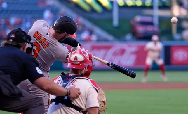Baltimore Orioles' Taylor Ward, center, hits a solo home run as home plate umpire John Libka, left, and Los Angeles Angels catcher Logan O'Hoppe watch during the first inning of a baseball game Monday, June 22, 2026, in Anaheim, Calif. (AP Photo/Mark J. Terrill)