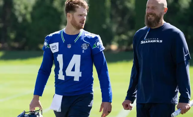 Seattle Seahawks offensive coordinator Brian Fleury, right, talks with quarterback Sam Darnold after a NFL football practice at the team's training facility, Tuesday, June 9, 2026, in Renton, Wash. (AP Photo/Stephen Brashear)