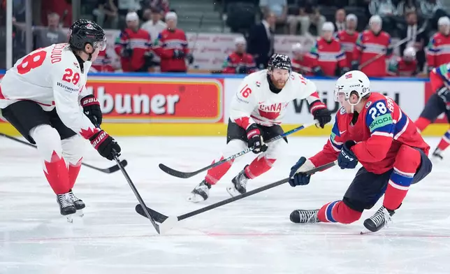 Canada's Zach Whitecloud (28), Canada's Connor Brown (16), Norway's Michael Brandsegg-Nygard (28) challenge for the puck during the 2026 IIHF Men's Ice Hockey World Championship bronze medal match between Canada and Norway, in Zurich, Switzerland, Sunday, May 31, 2026. (AP Photo/Darko Bandic)