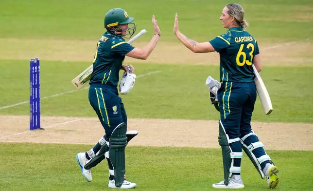 Beth Mooney, left, and Ashleigh Gardner of Australia celebrate a 100 partnership during the Women's T20 World Cup match between Australia and Netherlands in Southampton, England, Saturday June 20, 2026. (Andrew Matthews/PA via AP)