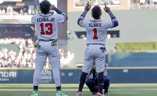 Atlanta Braves' Ronald Acuna Jr. (13) and Ozzie Albies (1) react after the Canadian and United States national anthems before a baseball game against the Toronto Blue Jays, Thursday, June 4, 2026, in Atlanta. (AP Photo/Erik S. Lesser)
