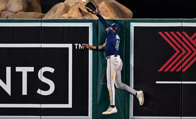 Tampa Bay Rays left fielder Chandler Simpson (14) makes a catch at the wall against the Los Angeles Angels in the eighth inning of a baseball game Friday, June 12, 2026, in Anaheim, Calif. (AP Photo/Wally Skalij)