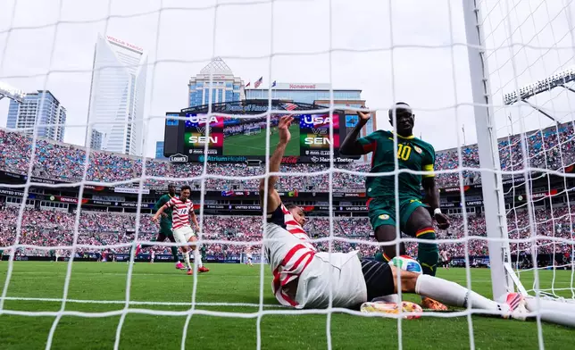 Senegal forward Sadio Mané (10) scores against United States defender Miles Robinson, bottom, during the second half of an international friendly soccer match Sunday, May 31, 2026, in Charlotte, N.C. (AP Photo/Scott Kinser)