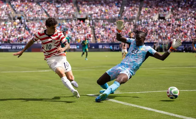 United States forward Christian Pulisic (10) shoots past Senegal forward Cherif Ndiaye (23) during the first half of an international friendly soccer match Sunday, May 31, 2026, in Charlotte, N.C. (AP Photo/Scott Kinser)