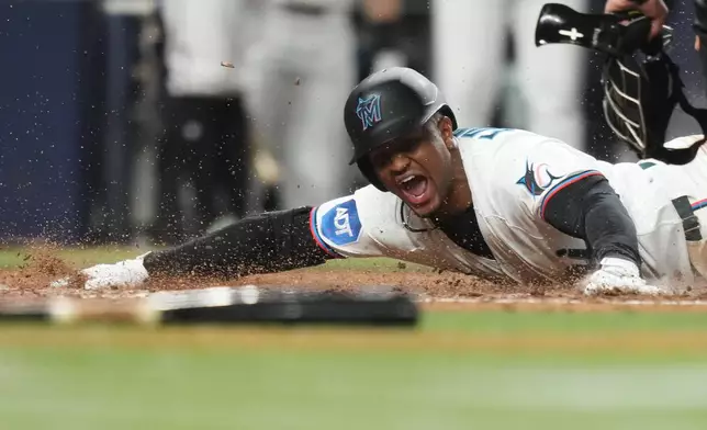 Miami Marlins' Xavier Edwards is out at the plate after hitting a triple to score Otto Lopez during the sixth inning of a baseball game against the Texas Rangers, Monday, June 22, 2026, in Miami. (AP Photo/Lynne Sladky)