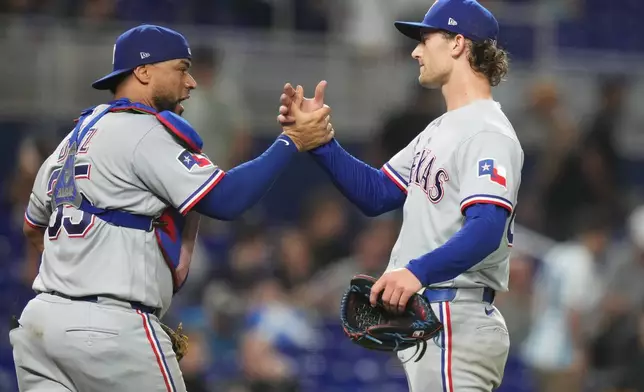 Texas Rangers catcher Elias Díaz (35) shakes hands with pitcher Jacob Latz, right, after the Rangers defeated the Miami Marlins in a baseball game, Monday, June 22, 2026, in Miami. (AP Photo/Lynne Sladky)