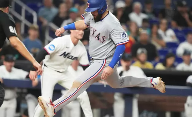 Texas Rangers' Jake Burger scores on a sacrifice fly hit by Elias Díaz during the eighth inning of a baseball game against the Miami Marlins, Monday, June 22, 2026, in Miami. (AP Photo/Lynne Sladky)
