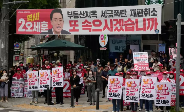 Supporters of Seoul mayoral candidate Oh Se-hoon of the main opposition People Power Party hold signs during an election campaign for June 3 nationwide simultaneous local elections in Seoul, South Korea, Monday, June 1, 2026. (AP Photo/Ahn Young-joon)