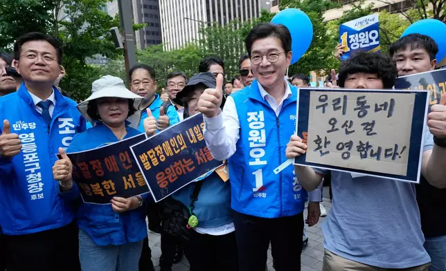 Seoul mayoral candidate Chong Won-o, third from right, of the ruling Democratic Party poses with supporters during an election campaign for June 3 nationwide simultaneous local elections in Seoul, South Korea, Tuesday, June 2, 2026. (AP Photo/Ahn Young-joon)