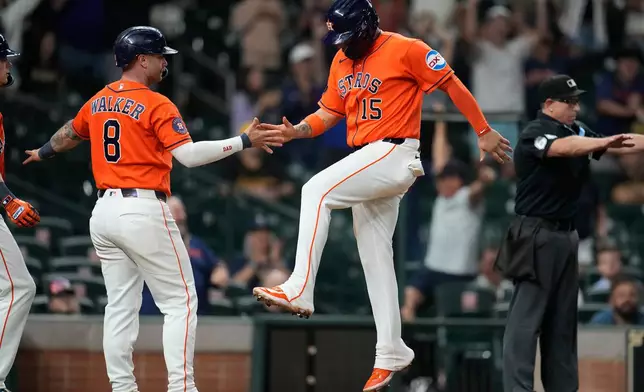 Houston Astros' Christian Walker (8) and Isaac Paredes (15) celebrate their runs scored on Cam Smith's RBI triple for the go-ahead runs against the Pittsburgh Pirates during the eighth inning of a baseball game, Wednesday, June 3, 2026, in Houston. (AP Photo/Karen Warren)