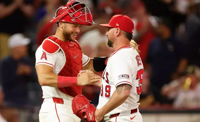 Los Angeles Angels catcher Logan O'Hoppe, left, Los Angeles Angels relief pitcher Kirby Yates, right, react following the Los Angeles Angels' victory over the Athletics during a baseball game Saturday, June 27, 2026, in Anaheim, Calif. (AP Photo/Caroline Brehman)