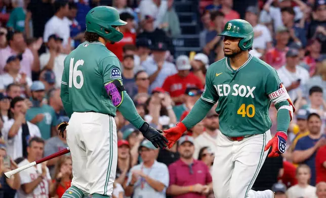 Boston Red Sox's Willson Contreras (40) is congratulated by teammate Jarren Duran (16) after hitting a solo home run during the third inning of a baseball game against the New York Yankees, Friday, June 26, 2026, in Boston. (AP Photo/Mary Schwalm)