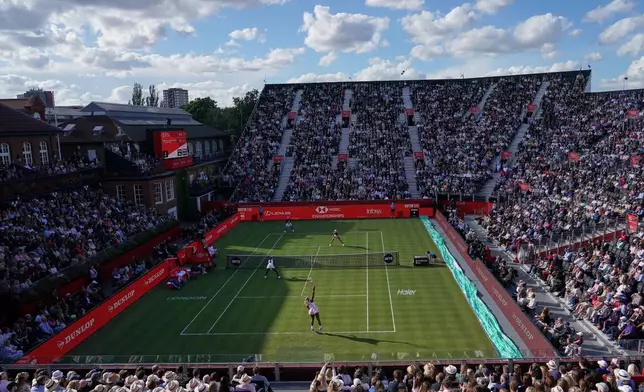 Serena Williams of the United States, bottom right, serves as she and playing partner Victoria Mboko of Canada play against Nicole Melichar-Martinez of Canada and Erin Routliffe of New Zealand during their first round doubles match at the Queen's Club tennis championships in London, Tuesday, June 9, 2026. (AP Photo/Alberto Pezzali)