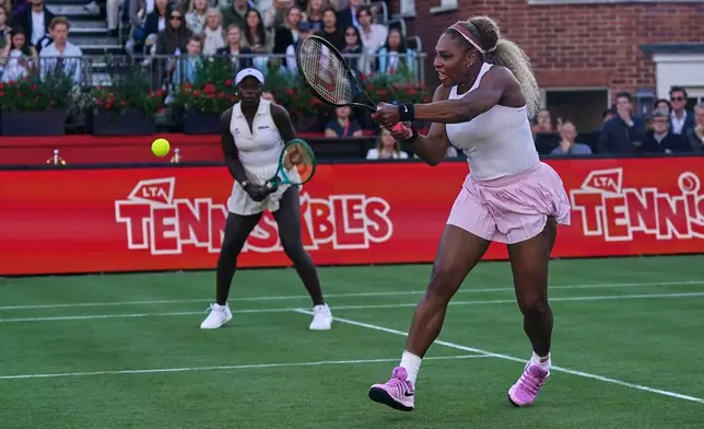 Serena Williams of the United States, right, hits a return as she and playing partner Victoria Mboko of Canada play against Nicole Melichar-Martinez of Canada and Erin Routliffe of New Zealand during their first round doubles match at the Queen's Club tennis championships in London, Tuesday, June 9, 2026. (AP Photo/Alberto Pezzali)