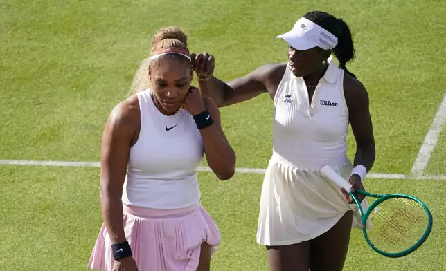 Serena Williams of the United States, left, talks to playing partner Victoria Mboko of Canada as they play against Nicole Melichar-Martinez of Canada and Erin Routliffe of New Zealand during their first round doubles match at the Queen's Club tennis championships in London, Tuesday, June 9, 2026. (AP Photo/Alberto Pezzali)