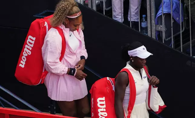 Serena Williams of the United States, left, waits with playing partner Victoria Mboko of Canada to walk onto court to play Nicole Melichar-Martinez of Canada and Erin Routliffe of New Zealand for their first round doubles match at the Queen's Club tennis championships in London, Tuesday, June 9, 2026. (AP Photo/Alberto Pezzali)