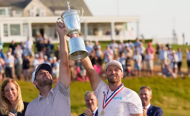 Wyndham Clark celebrates with his caddie David Pelekoudas after winning the U.S. Open golf tournament at Shinnecock Hills Golf Club in Southampton, N.Y., Sunday, June 21, 2026. (AP Photo/David J. Phillip)