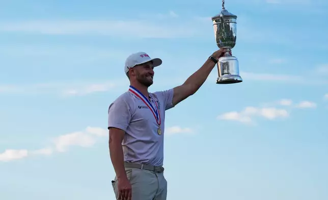 Wyndham Clark holds the trophy after winning the U.S. Open golf tournament at Shinnecock Hills Golf Club in Southampton, N.Y., Sunday, June 21, 2026. (AP Photo/Seth Wenig)