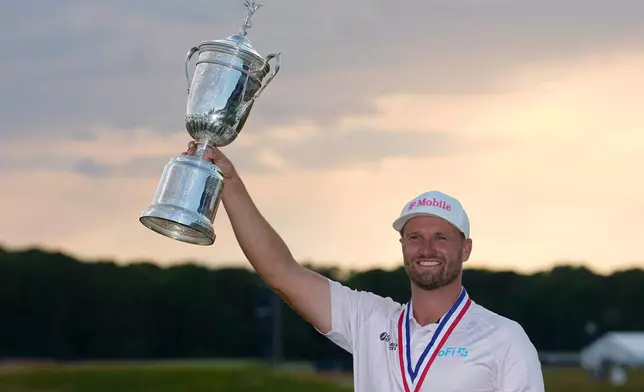 Wyndham Clark holds the trophy after winning the U.S. Open golf tournament at Shinnecock Hills Golf Club in Southampton, N.Y., Sunday, June 21, 2026. (AP Photo/Gerald Herbert)