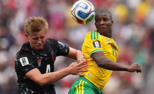 Canada's Luc de Fougerolles (4) and South Africa's Mbekezeli Mbokazi (14) jump for the ball during the World Cup round of 32 soccer match between South Africa and Canada in Inglewood, Calif., near Los Angeles, Sunday, June 28, 2026. (AP Photo/Manu Fernandez)