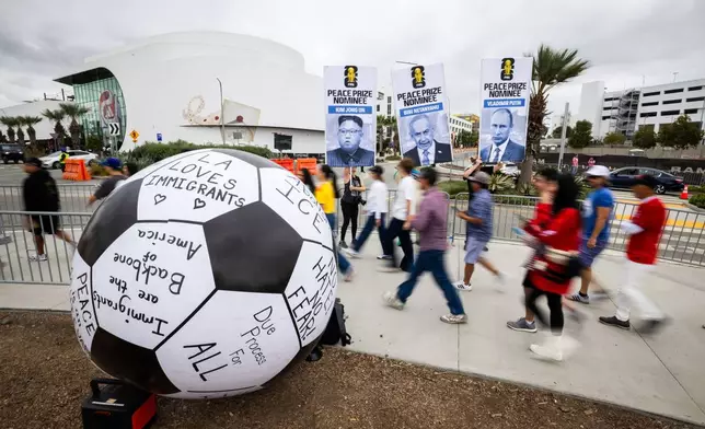 Fans walk past protesters before a World Cup round of 32 soccer match between South Africa and Canada in Inglewood, Calif., near Los Angeles, Sunday, June 28, 2026. (AP Photo/Ethan Swope)
