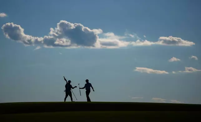 Wyndham Clark hands his club to his caddie on the 10th hole during the third round of the U.S. Open golf tournament at Shinnecock Hills Golf Club in Southampton, N.Y., Saturday, June 20, 2026.(AP Photo/Gerald Herbert)