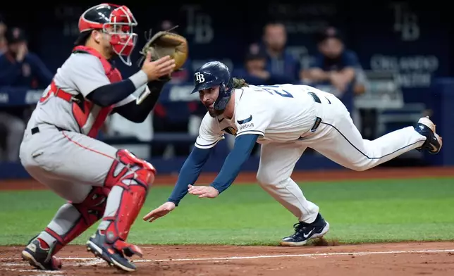 Tampa Bay Rays' Ryan Vilade, right, scores ahead of the throw to Boston Red Sox catcher Mickey Gasper on an RBI single by Cedric Mullins during the fourth inning of a baseball game Tuesday, June 9, 2026, in St. Petersburg, Fla. (AP Photo/Chris O'Meara)