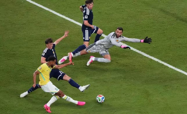 Brazil's Matheus Cunha (9) scores a goal on Scotland goalkeeper Angus Gunn (1) during the World Cup Group C soccer match in Miami Gardens, Fla., Wednesday, June 24, 2026. (AP Photo/Marta Lavandier)