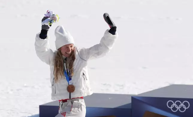 FILE - Jessie Diggins, of the United States, waves to the fans when walking away from the podium after winning the bronze medal in the cross country skiing women's 10-kilometer interval start free at the 2026 Winter Olympics, in Tesero, Italy, Feb. 12, 2026. (AP Photo/Evgeniy Maloletka, File)