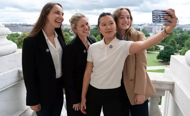 Olympians Julia Kern, from left, Jessie Diggins, Bea Kim and Olivia Giaccio, take a selfie from the Senate Minority Leader balcony during a meeting to advocate for clean air, clean water and a healthy planet on Capitol Hill, Tuesday, June 23, 2026, in Washington. (AP Photo/Jose Luis Magana)