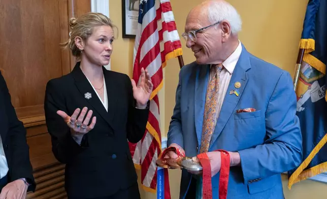 Rep. Paul Tonko, D-N.Y., speaks with Olympian Jessie Diggins as she shows him her medals during a meeting to advocate for clean air, clean water and a healthy planet on Capitol Hill Tuesday, June 23, 2026, in Washington. (AP Photo/Jose Luis Magana)
