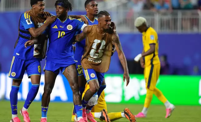 Curaçao's Leandro Bacuna and teammates celebrate after a draw against Ecuador during a World Cup Group E soccer match in Kansas City, Mo., Saturday, June 20, 2026. (AP Photo/Ed Zurga)