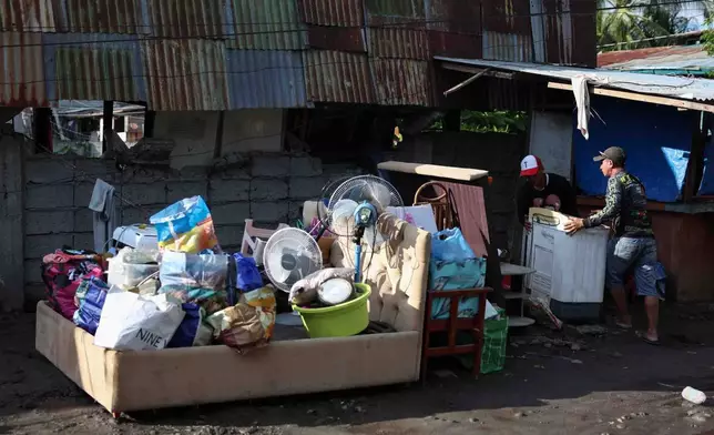 Residents save their belongings as they evacuate from their damaged houses following an earthquake in General Santos, Philippines Tuesday, June 9, 2026. (AP Photo/Basilio Sepe)