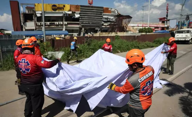Rescuers install a tent as they prepare for a search operation following an earthquake in General Santos, Philippines, Tuesday, June 9, 2026. (AP Photo/Basilio Sepe)