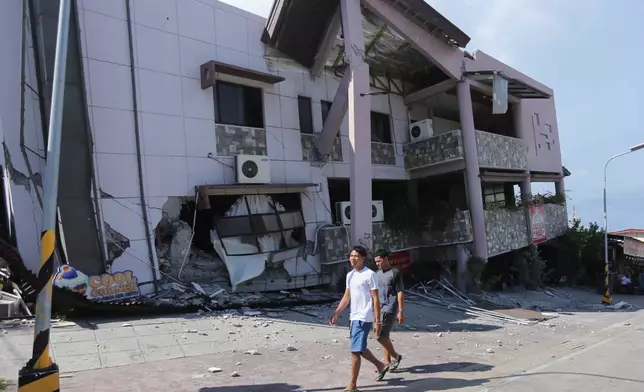 Residents pass by a collapsed structure after an earthquake in General Santos, Philippines on Monday, June 8, 2026. (AP Photo)