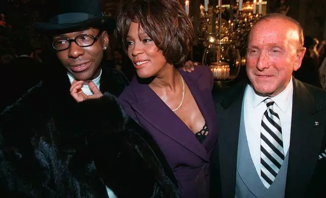 FILE - Bobby Brown, left, and Whitney Houston appear with music producer Clive Davis, right, at a pre-Grammy party in New York on Feb. 24, 1998. (AP Photo/Stuart Ramson, File)