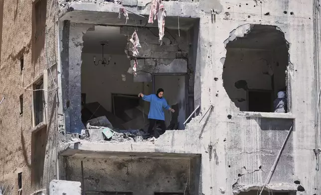 A woman walks through her apartment damaged in Israeli strikes in the southern port city of Tyre, Lebanon, Thursday, June 18, 2026. (AP Photo/Hassan Ammar)