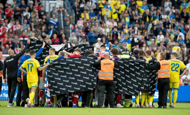 Denmark's and Ukraine's players accompany Christian Eriksen to a waiting ambulance during the international friendly soccer match between Denmark and Ukraine in Odense, Denmark, Sunday, June 7, 2026, after Eriksen has collapsed on the field again while playing for Denmark’s national team. (Bo Amstrup/Ritzau Scanpix via AP)