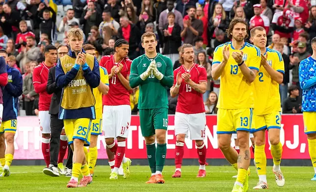 Denmark's and Ukraine's players walk on the pitch after the international friendly soccer match between Denmark and Ukraine was cancelled in Odense, Denmark, Sunday, June 7, 2026, after Christian Eriksen has collapsed on the field again while playing for Denmark’s national team. (Bo Amstrup/Ritzau Scanpix via AP)